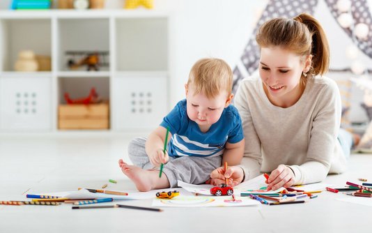 Haus-Familie-Wohnen-Serie-6 Mutter zeichnet mit ihrem Kleinkind